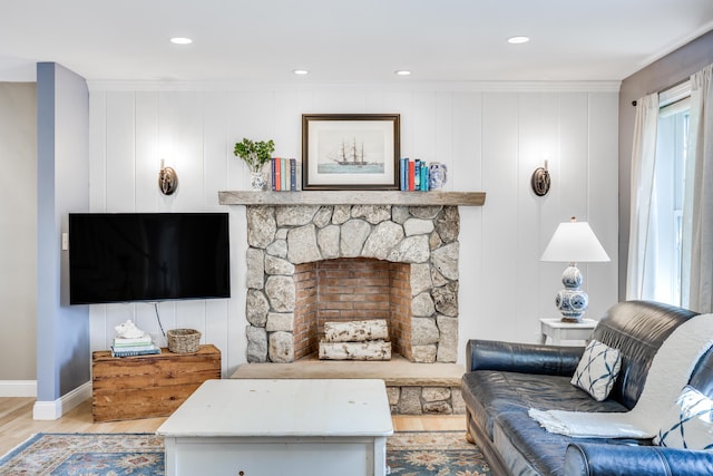 living room with a wealth of natural light, crown molding, and light hardwood / wood-style floors