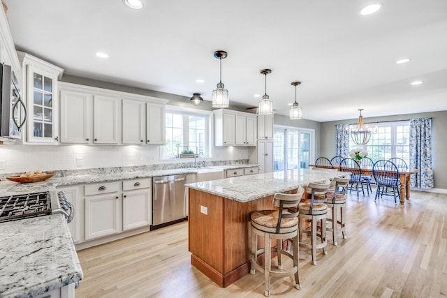 kitchen featuring white cabinets, backsplash, a center island, and appliances with stainless steel finishes