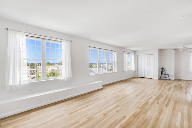 unfurnished living room with ceiling fan, a healthy amount of sunlight, and light hardwood / wood-style flooring