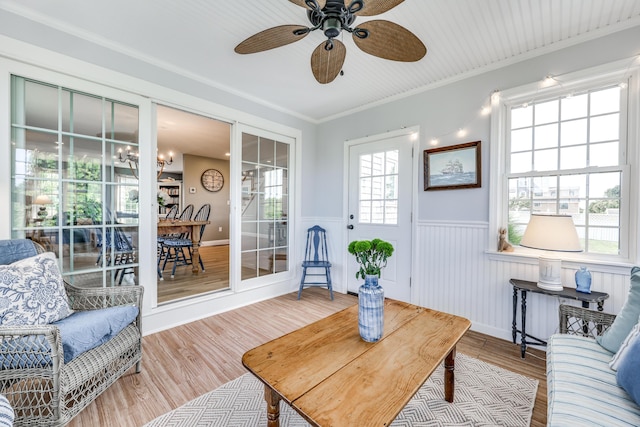 living room with hardwood / wood-style flooring, ornamental molding, and ceiling fan