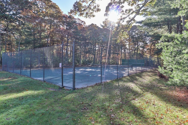 view of tennis court featuring a yard