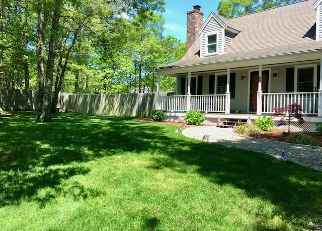 view of front of house featuring fence, a shingled roof, a front yard, a chimney, and covered porch