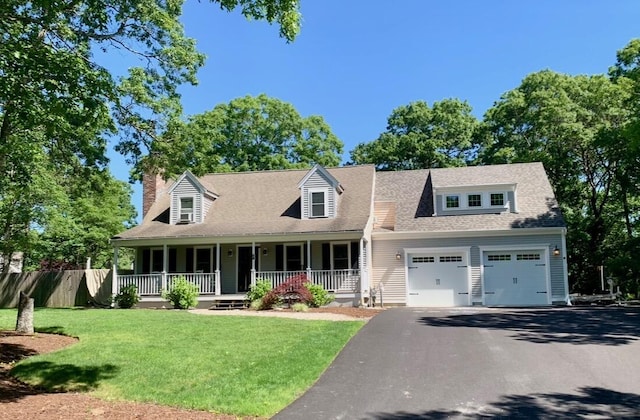 cape cod house with a shingled roof, an attached garage, aphalt driveway, a porch, and a front yard