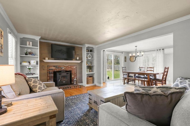 living area with a wood stove, wood finished floors, an AC wall unit, an inviting chandelier, and ornamental molding