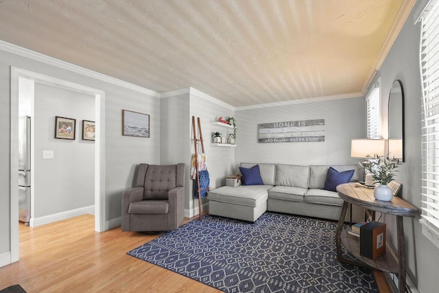living room featuring crown molding, baseboards, a healthy amount of sunlight, and wood finished floors