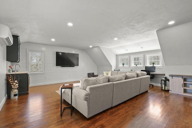 living area featuring baseboards, dark wood finished floors, a wall mounted AC, and lofted ceiling