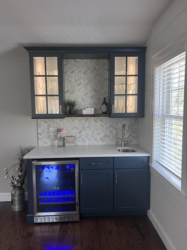 bar featuring decorative backsplash, wine cooler, indoor wet bar, plenty of natural light, and a sink
