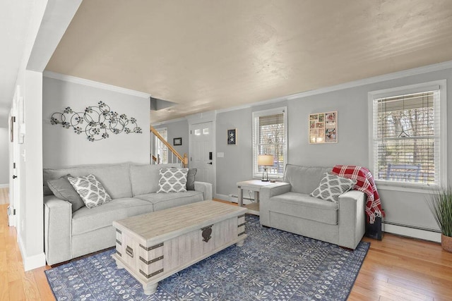 living area featuring wood-type flooring, a baseboard radiator, a wealth of natural light, and stairway