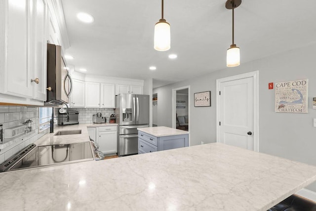 kitchen with appliances with stainless steel finishes, tasteful backsplash, white cabinets, a peninsula, and recessed lighting