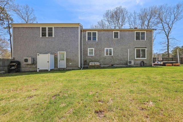 rear view of property featuring a lawn, fence, ac unit, and a chimney
