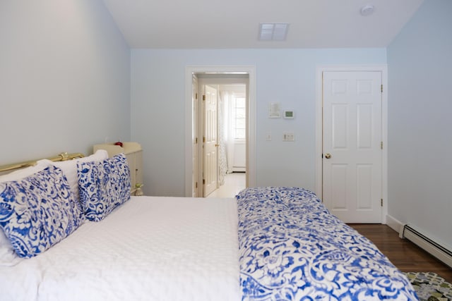 bedroom with dark wood-type flooring and baseboard heating