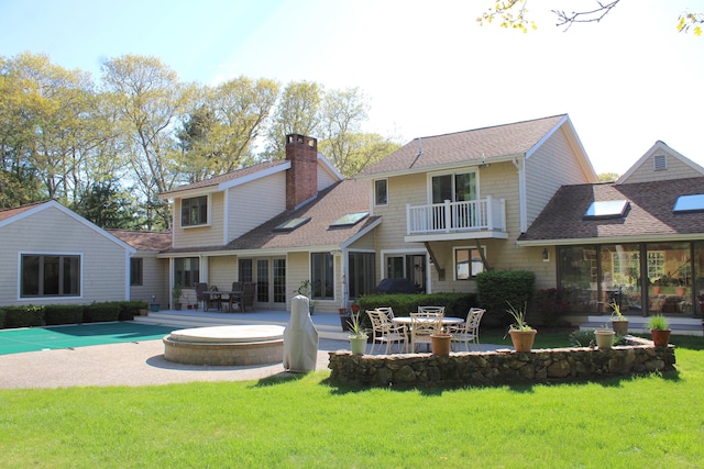 98 Bunker Hill Rd, Osterville, MA 02655 - rear view of house featuring a lawn, a balcony, a covered pool, roof with shingles, and a chimney
