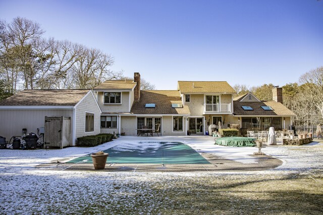 98 Bunker Hill Rd, Osterville, MA 02655 - rear view of house featuring a balcony, a covered pool, a chimney, a shingled roof, and a patio