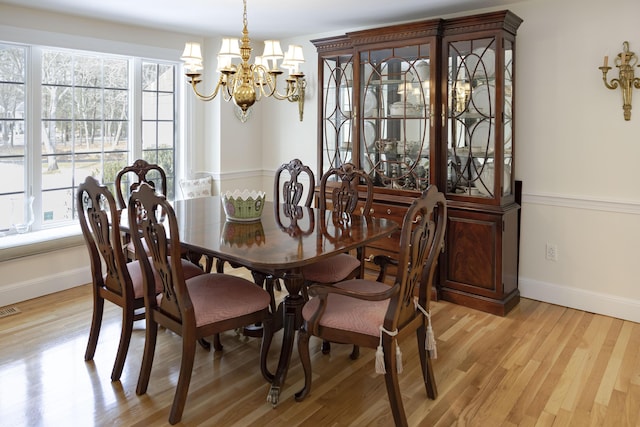 dining room with light hardwood / wood-style flooring and a chandelier