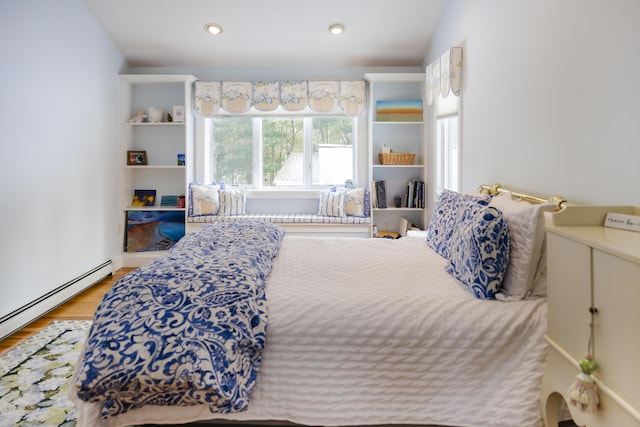 bedroom with baseboard heating and wood-type flooring