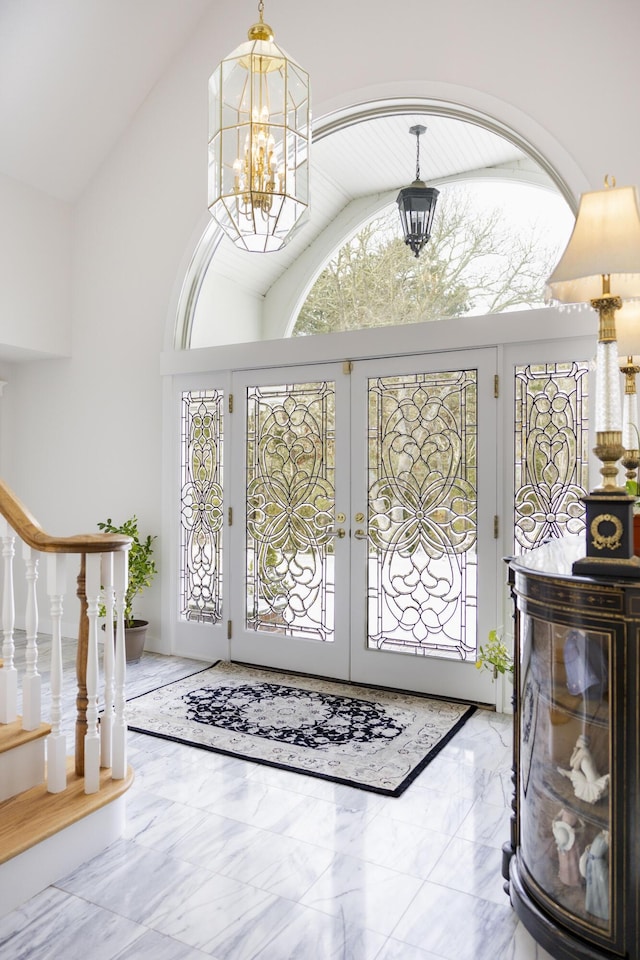 entryway featuring a notable chandelier, high vaulted ceiling, and french doors