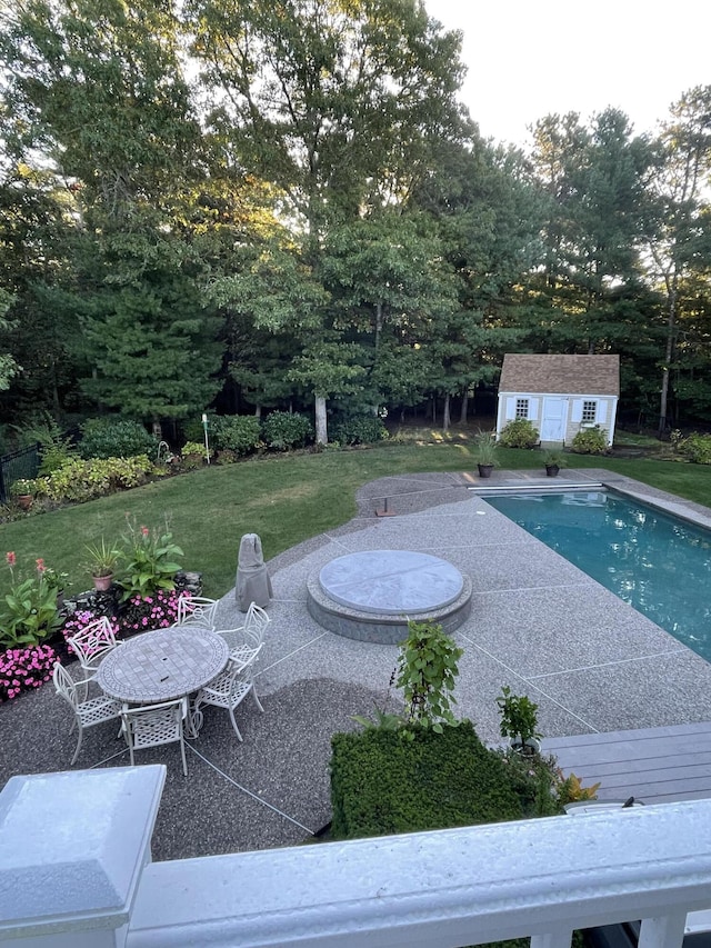 view of pool featuring a shed, a patio area, and a lawn