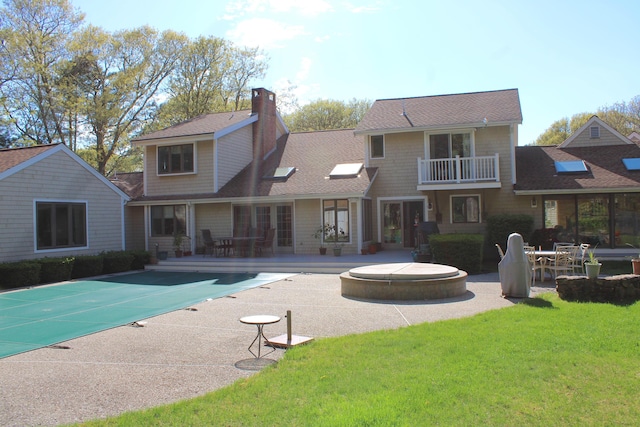 98 Bunker Hill Rd, Osterville, MA 02655 - back of property with a covered pool, a patio area, roof with shingles, a lawn, and a balcony