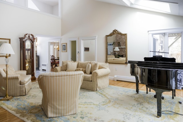 living area featuring hardwood / wood-style flooring, high vaulted ceiling, and a skylight