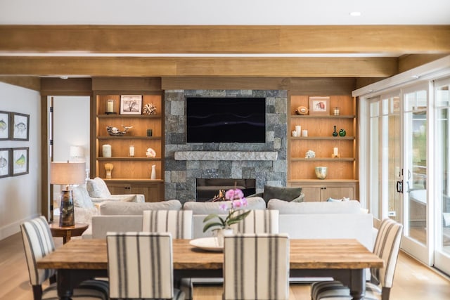2 Bridge St, East Falmouth, MA 02536 - dining room featuring a fireplace, light wood finished floors, built in shelves, and baseboards