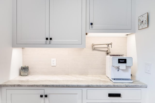 2 Bridge St, East Falmouth, MA 02536 - kitchen featuring tasteful backsplash, light stone counters, and white cabinetry