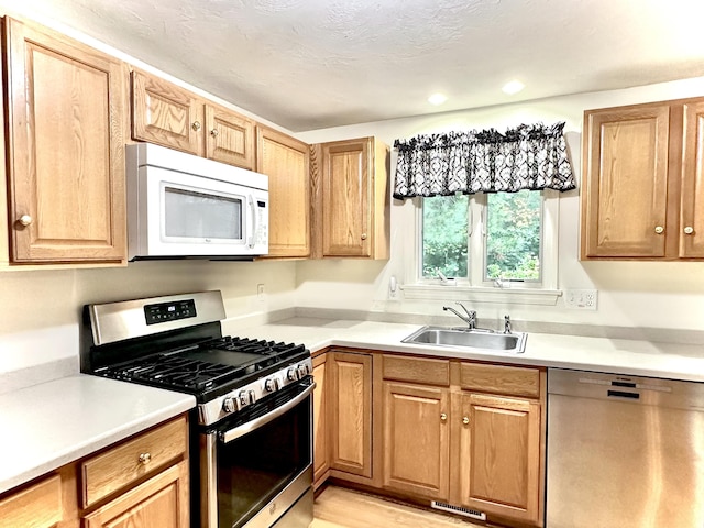 kitchen with a sink, light countertops, stainless steel appliances, and visible vents