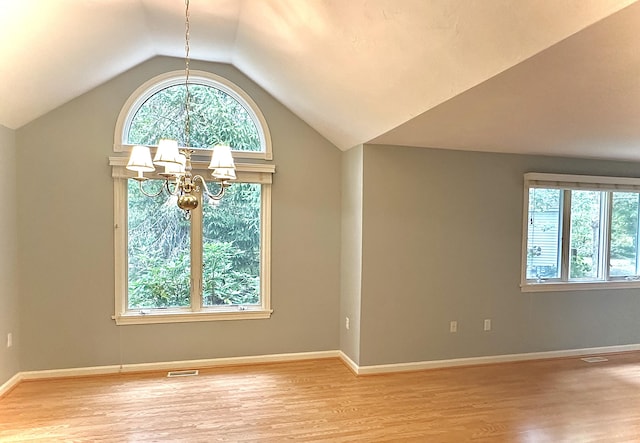 interior space with a chandelier, light hardwood / wood-style flooring, and vaulted ceiling