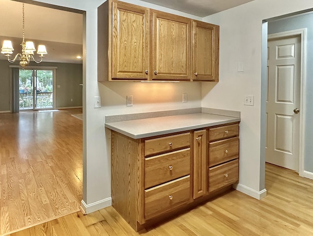 kitchen featuring a notable chandelier, decorative light fixtures, and light hardwood / wood-style floors