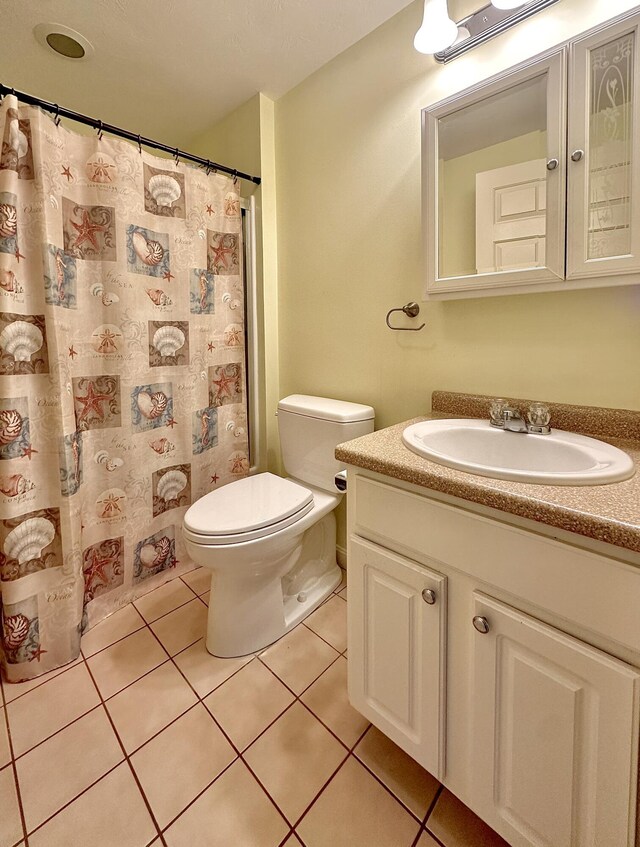 bathroom featuring toilet, tile patterned flooring, and vanity