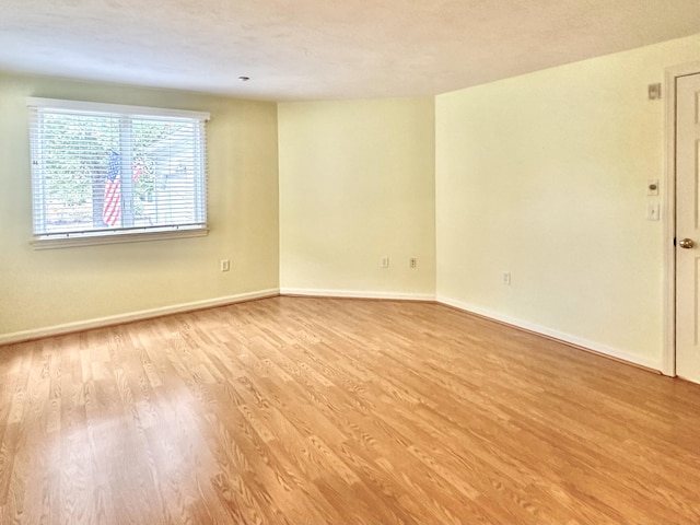empty room featuring baseboards and wood finished floors