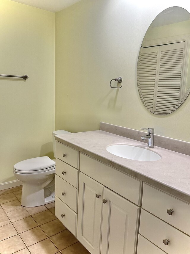 bathroom with toilet, tile patterned floors, and vanity