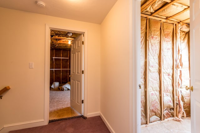 hallway featuring carpet flooring and baseboards