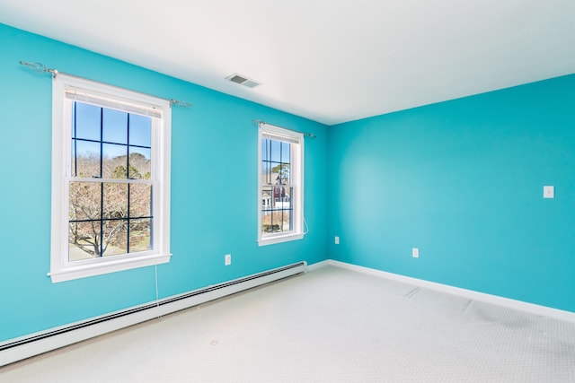 carpeted empty room featuring visible vents, a baseboard heating unit, baseboards, and a healthy amount of sunlight