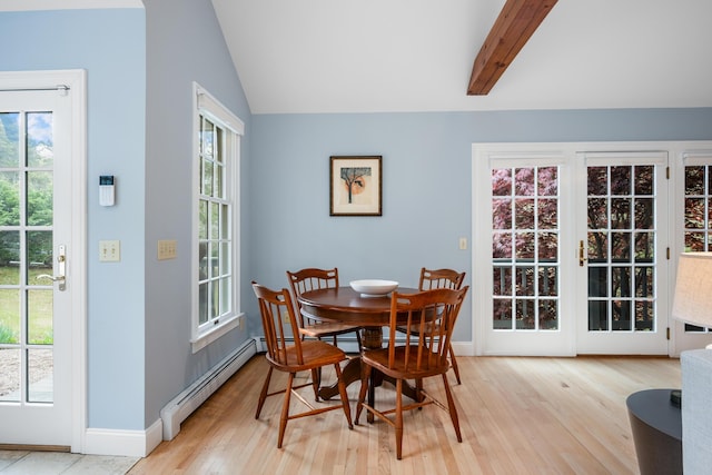 dining space featuring a baseboard radiator, light wood-style flooring, plenty of natural light, and baseboards