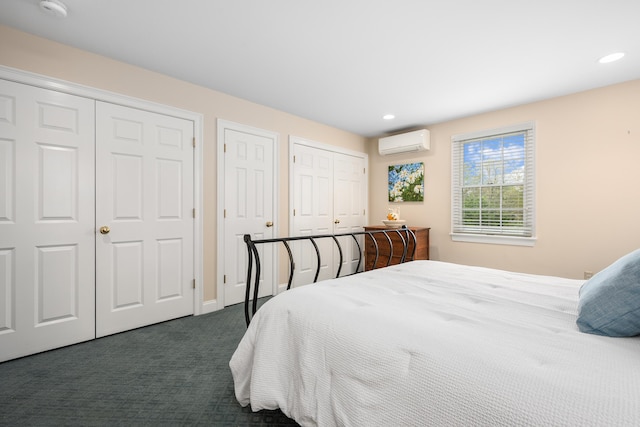 bedroom featuring two closets, dark carpet, an AC wall unit, recessed lighting, and baseboards