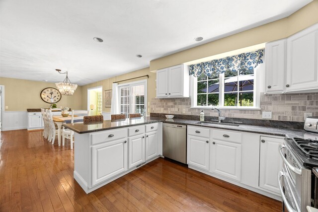 67 Sea Meadow Cir, Centerville, MA 02632 - kitchen featuring stainless steel appliances, a peninsula, white cabinetry, a chandelier, and tasteful backsplash