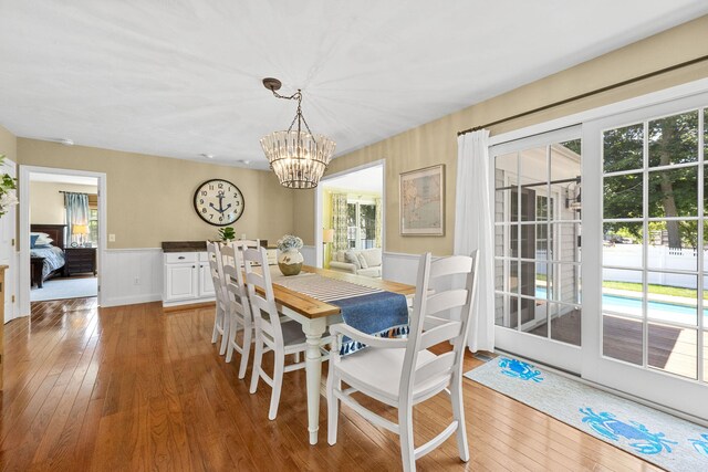 67 Sea Meadow Cir, Centerville, MA 02632 - dining space featuring light wood-type flooring, a chandelier, a wainscoted wall, and plenty of natural light