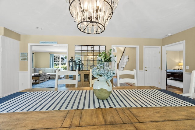67 Sea Meadow Cir, Centerville, MA 02632 - dining area featuring a chandelier, wainscoting, wood finished floors, and stairway