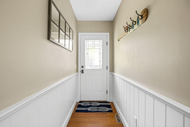 67 Sea Meadow Cir, Centerville, MA 02632 - doorway to outside featuring wood finished floors, wainscoting, and a decorative wall