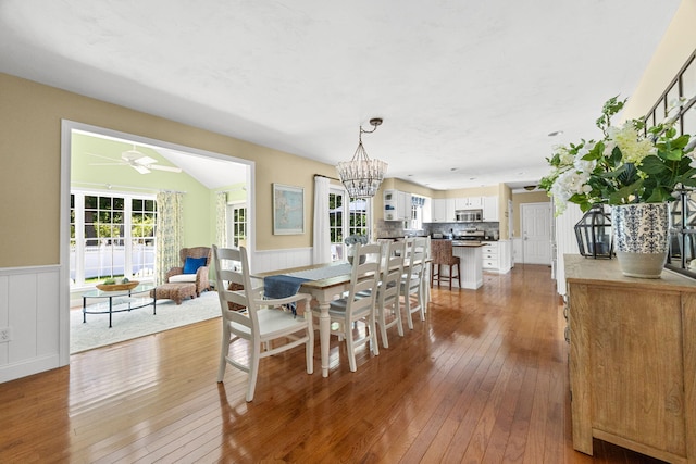 67 Sea Meadow Cir, Centerville, MA 02632 - dining space with hardwood / wood-style floors, a wainscoted wall, a ceiling fan, and a chandelier
