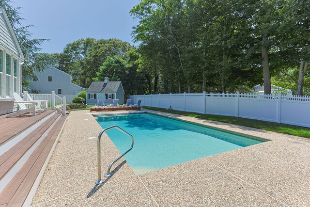 67 Sea Meadow Cir, Centerville, MA 02632 - view of swimming pool featuring a fenced backyard, an outbuilding, a wooden deck, and a patio area