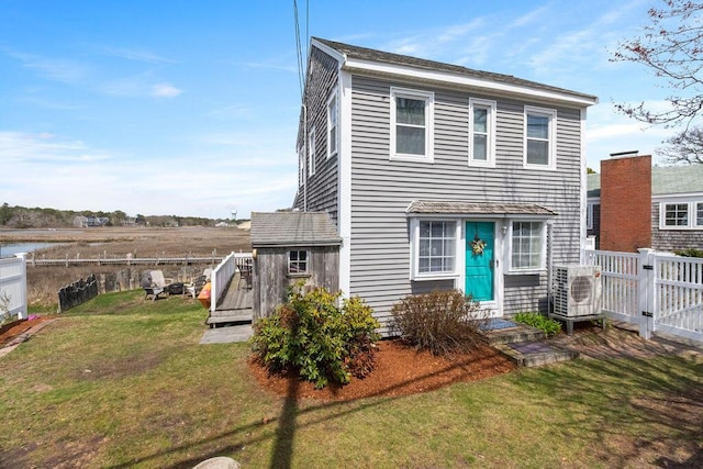 view of front of house featuring ac unit, a deck with water view, a front yard, a fenced backyard, and a gate