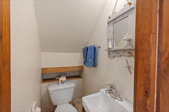 bathroom with a sink, lofted ceiling, and toilet