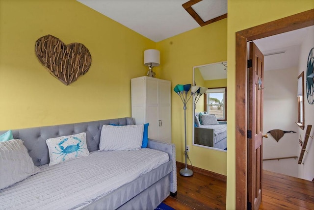 bedroom with baseboards and hardwood / wood-style flooring