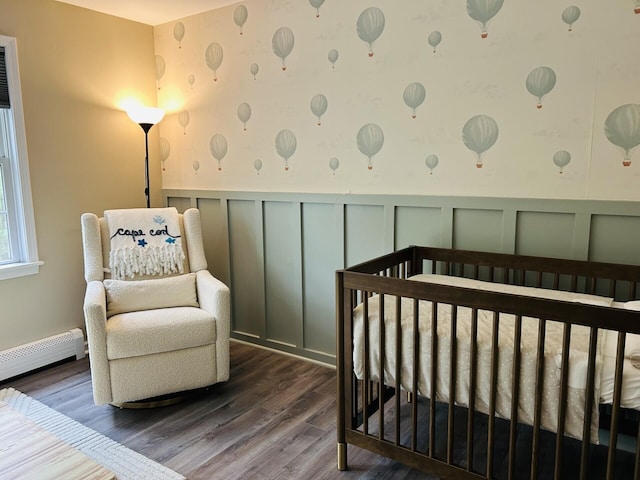 50 Great Hill Rd, Sandwich, MA 02563 - bedroom featuring a decorative wall, a baseboard heating unit, wood finished floors, a wainscoted wall, and a crib