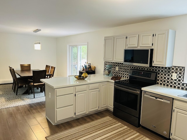 50 Great Hill Rd, Sandwich, MA 02563 - kitchen featuring stainless steel appliances, a peninsula, light countertops, and dark wood-style flooring