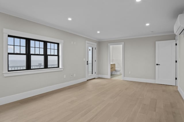 unfurnished living room with light wood-type flooring, a wall mounted air conditioner, and ornamental molding