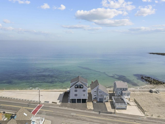 birds eye view of property with a water view and a beach view