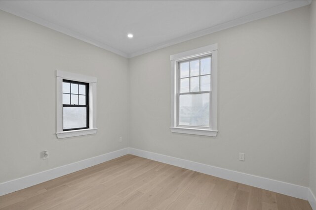 spare room with crown molding and light hardwood / wood-style flooring