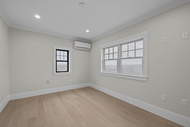 spare room featuring crown molding, light hardwood / wood-style flooring, and a wall unit AC